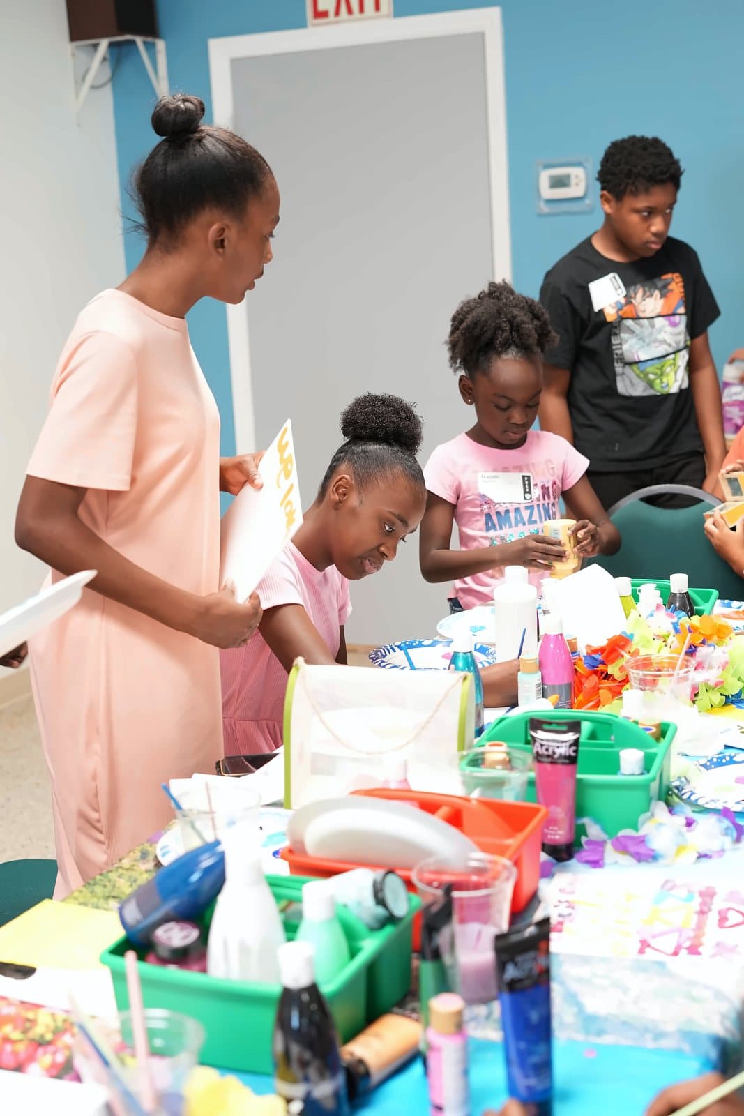 SWREA students and a teacher setting up an art table