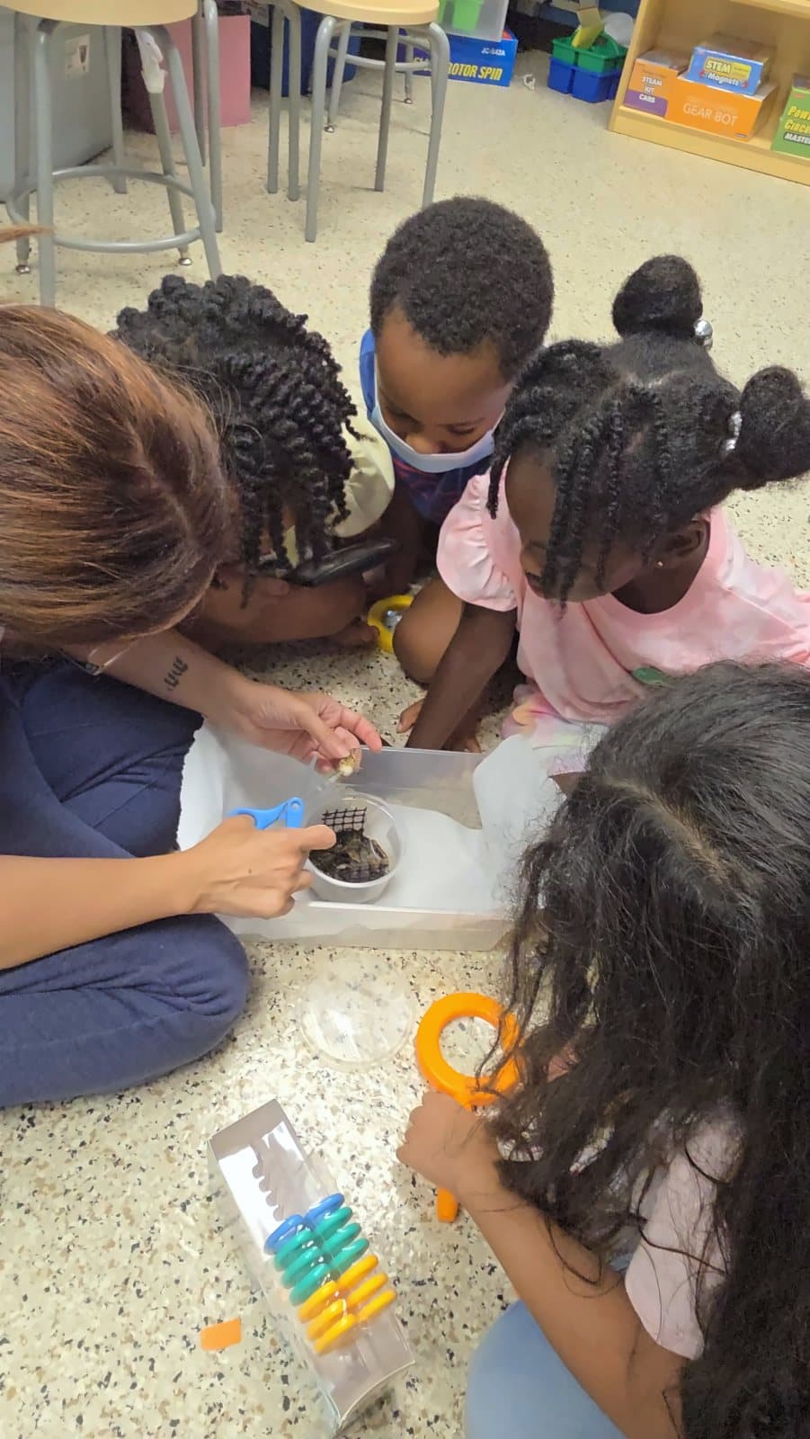 SWREA students and a teacher examining a specimen on the floor