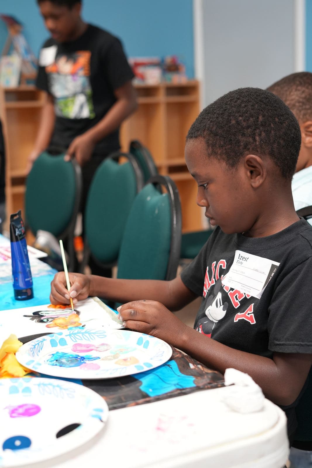 A SWREA student concentrating on a painting at his table