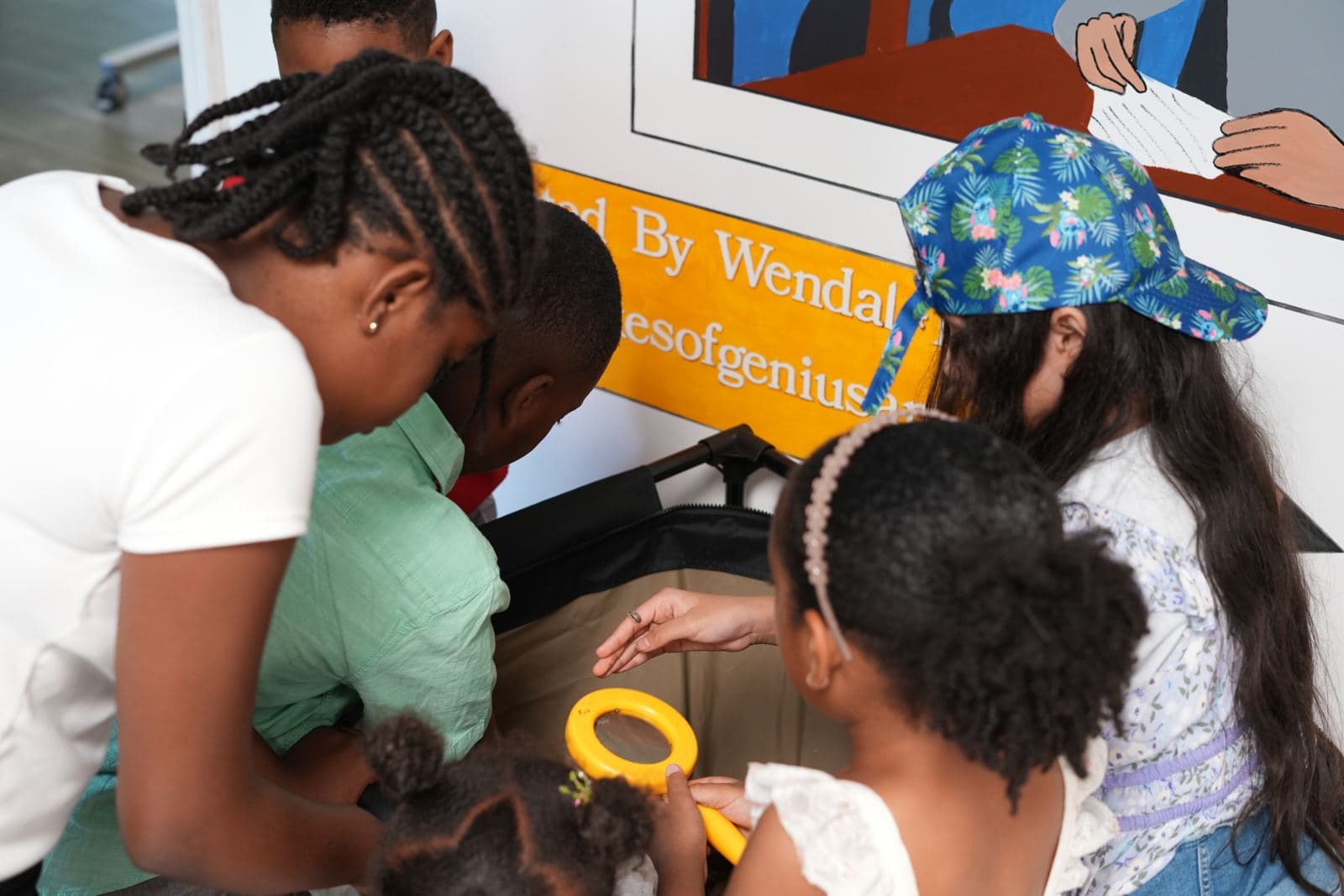 SWREA students leaning in together to look through a magnifying glass