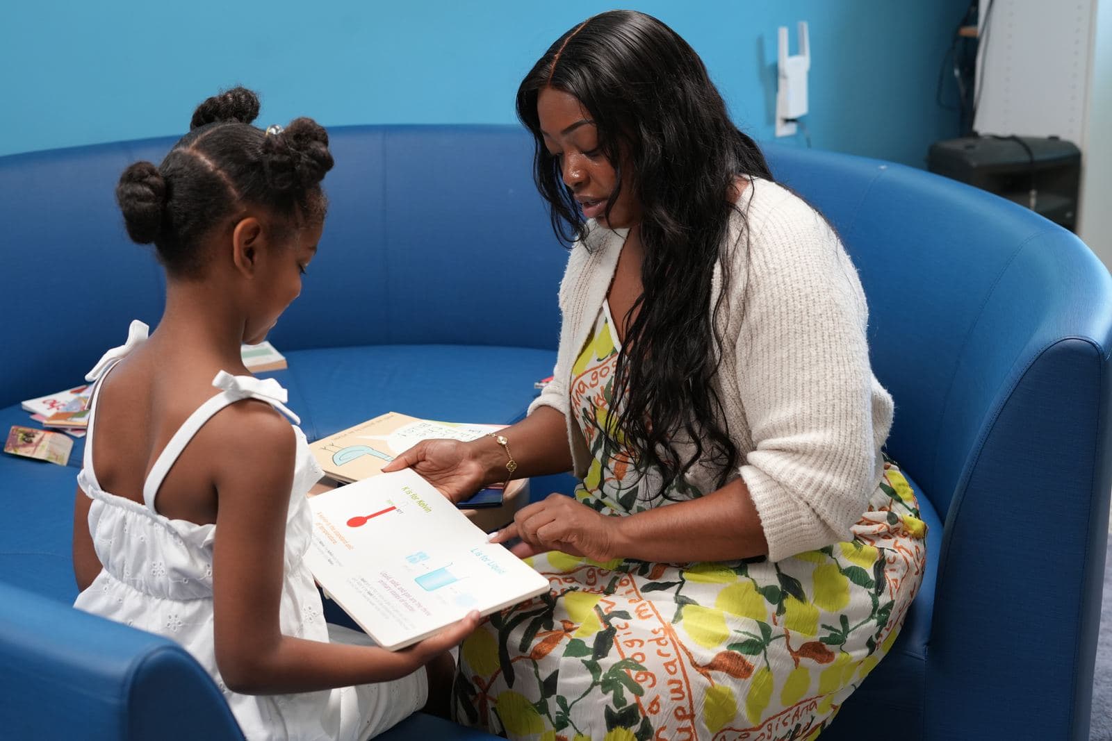 A SWREA student working one-on-one with an adult on a Montessori card material