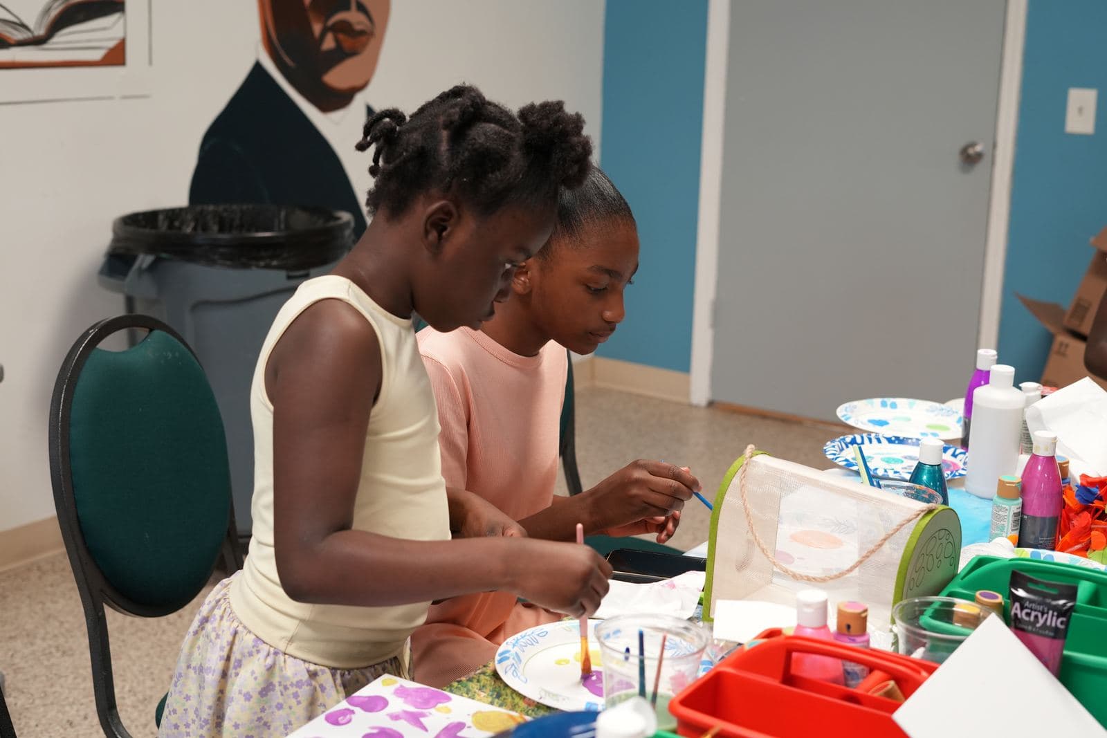 Two SWREA students painting side by side at a shared table