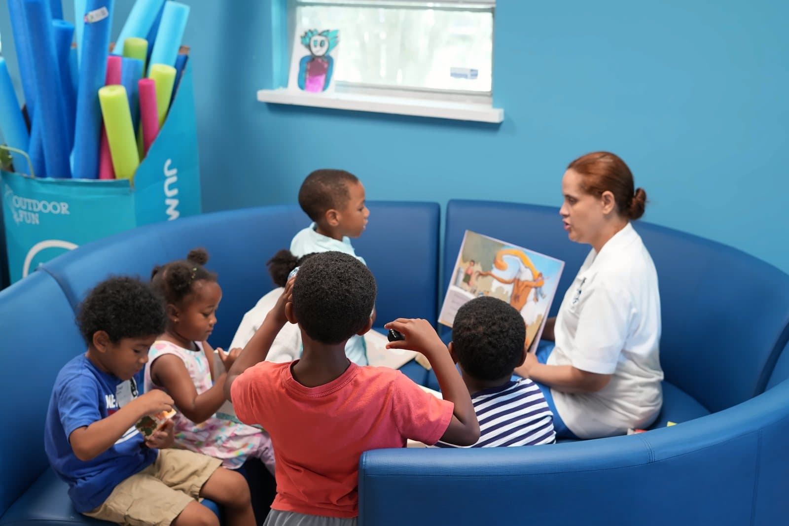A circle of SWREA students listening to their teacher read