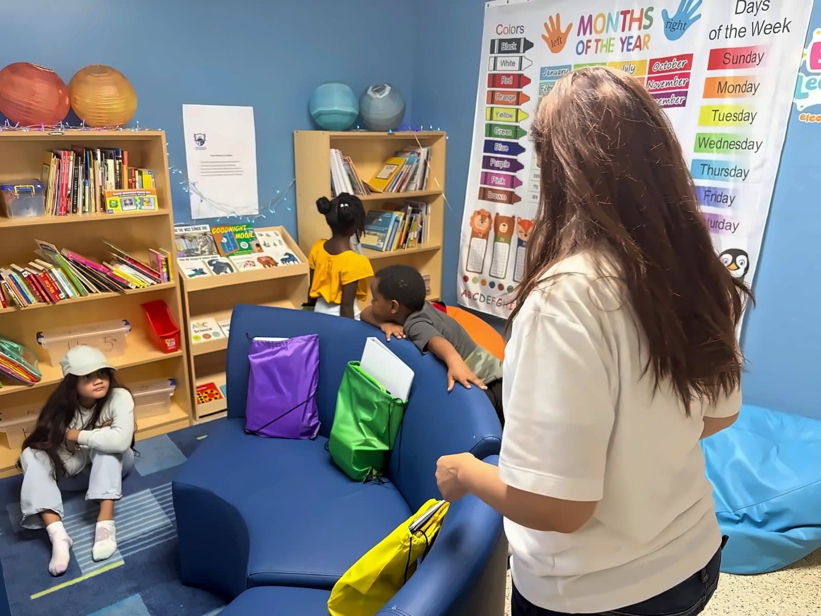 A SWREA teacher in the reading corner with students and books