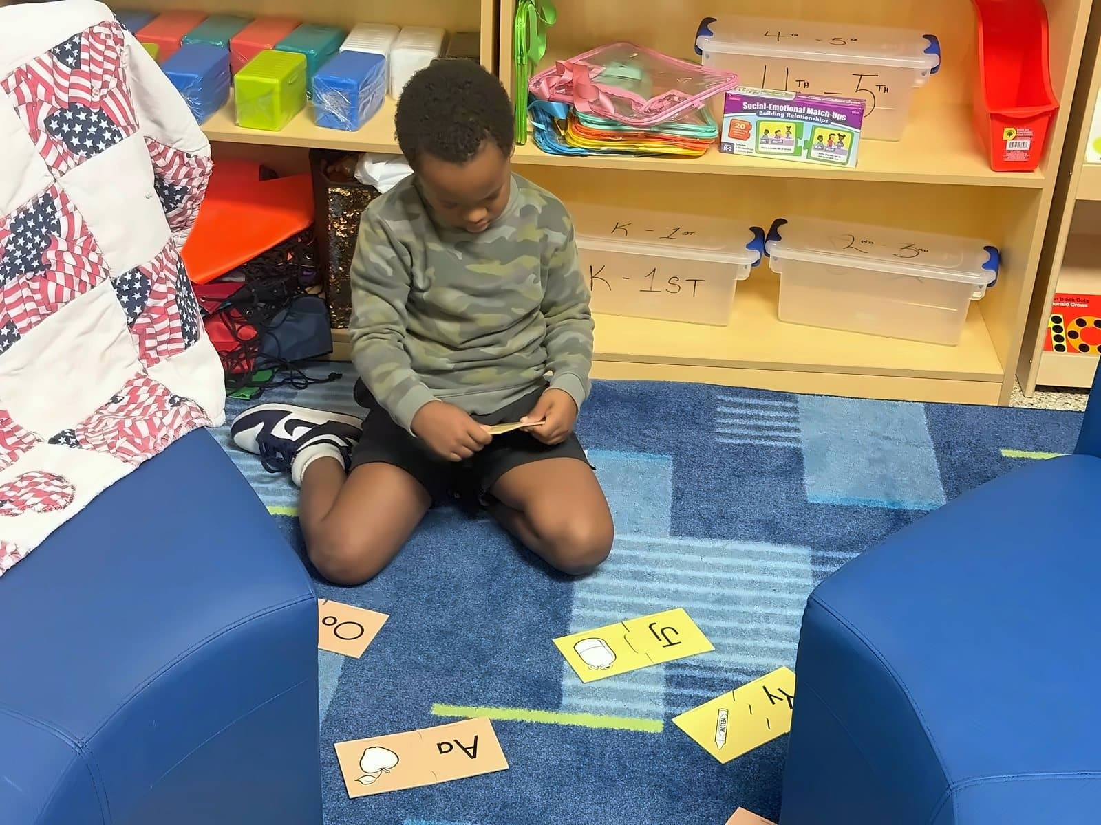 A SWREA student working with word cards on the reading rug